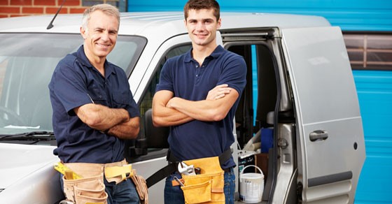 Men smiling with work belts